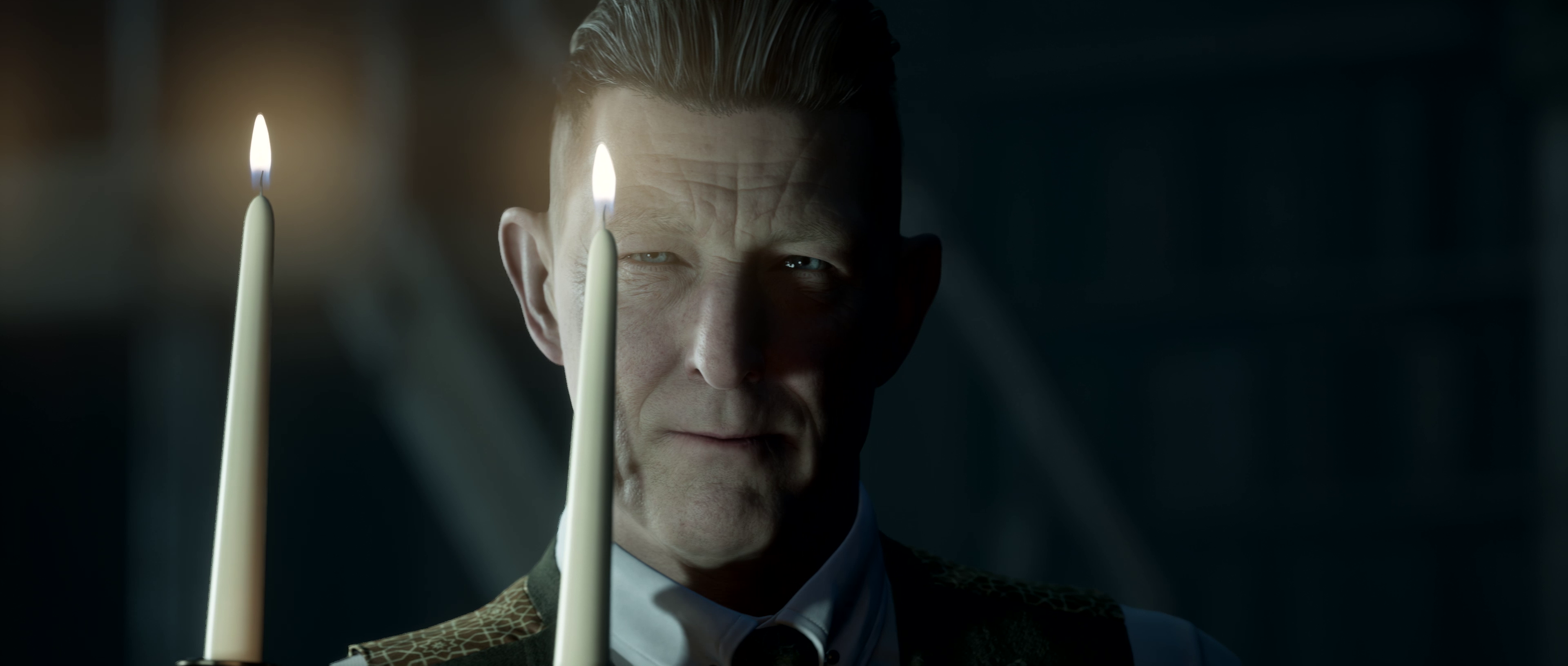 The Curator from The Dark Pictures Anthology stands behind two lit candles, his face partially obscured by shadow in a dimly lit room.